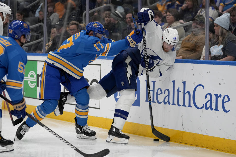 St. Louis Blues' Josh Leivo (17) pushes Tampa Bay Lightning's Ian Cole, right, during the second period of an NHL hockey game Saturday, Jan. 14, 2023, in St. Louis. (AP Photo/Jeff Roberson)