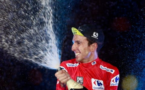 Mitchelton-Scott's British cyclist Simon Philip Yates celebrates on the podium after winning the 73rd edition of "La Vuelta" Tour of Spain cycling race - Credit: Getty Images
