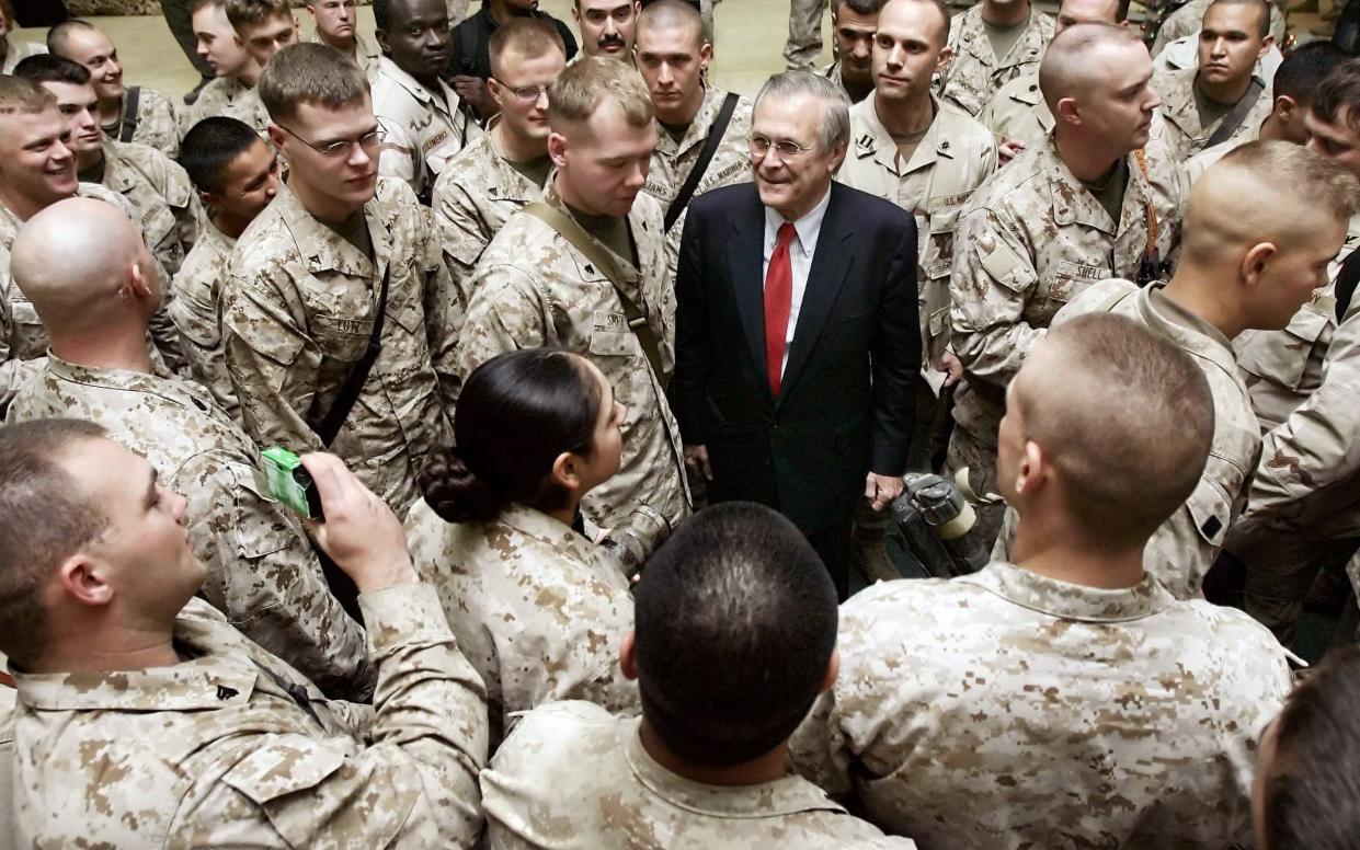 Rumsfeld surrounded by soldiers in Fallujah in 2005