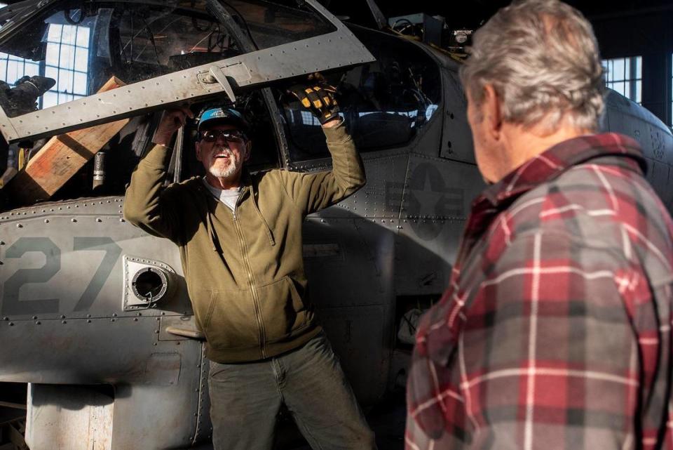 United States Air Force veteran John Hogrefe, 71, of Modesto, left, inspects a handle on a Bell AH-1W Cobra attack helicopter as fellow Air Force veteran John de Jong, 80, of Modesto, right, looks on inside Castle Air Museum’s restoration hanger in Atwater, Calif., on Wednesday, Jan. 12, 2022. According to Castle Air Museum Chief Executive Director Joe Pruzzo, the Bell AH-1W Cobra attack helicopter and a SH-60B Seahawk helicopter were acquired from Hawaii in 2021. When ready, the aircraft will be displayed on the Castle Air Museum grounds along with dozens of other vintage aircraft.