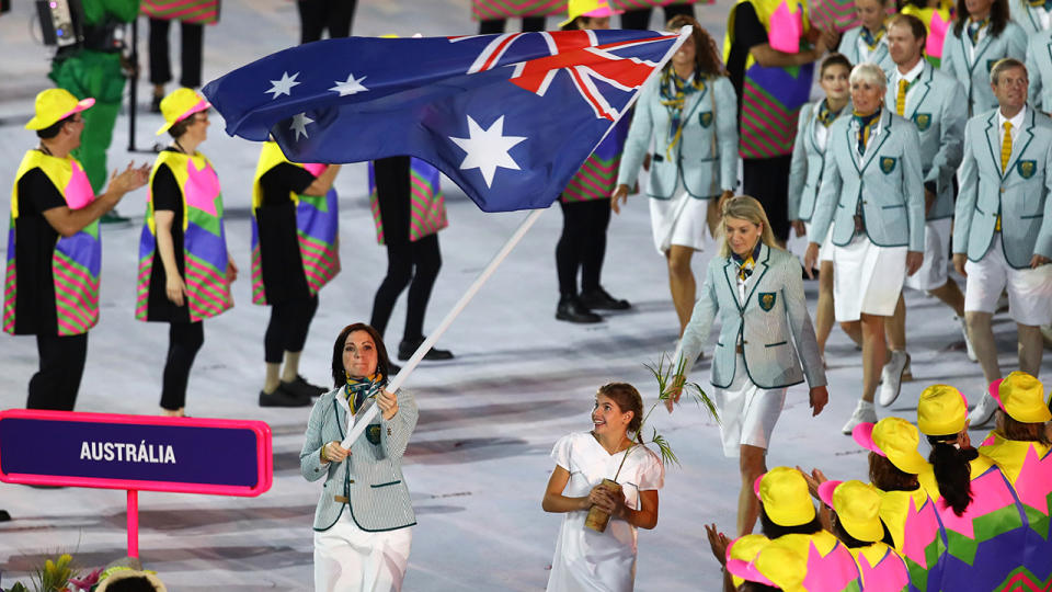 Anna Meares is shown carrying the Australian flag at the opening ceremony for the 2016 Rio Olympics.