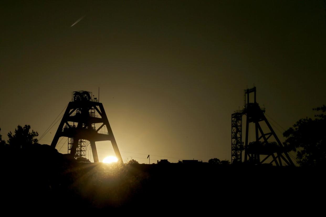 Mine shaft infrastructure is silhouetted against the setting sun at Oak Flat