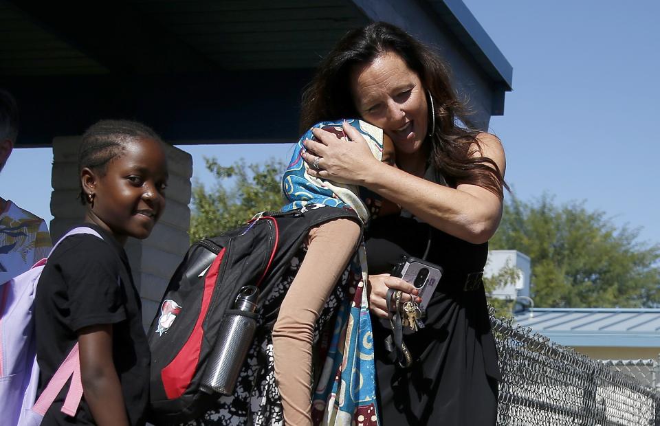 Director Lynette Faulkner, right, says goodbye to Durse Karayu, middle, and Riziki Nyongoco, left, tudents at Valencia Newcomer School at the end of the school day Thursday, Oct. 17, 2019, in Phoenix. Children from around the world are learning the English skills and American classroom customs they need to succeed at so-called newcomer schools. Valencia Newcomer School in Phoenix is among a handful of such public schools in the United States dedicated exclusively to helping some of the thousands of children who arrive in the country annually. (AP Photo/Ross D. Franklin)