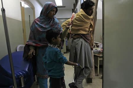 A woman assists her son suffering from Thalassemia as he undergoes a blood transfusion process at Pakistan Institute of Medical Sciences (PIMS) in Islamabad December 5, 2014. REUTERS/Faisl Mahmood