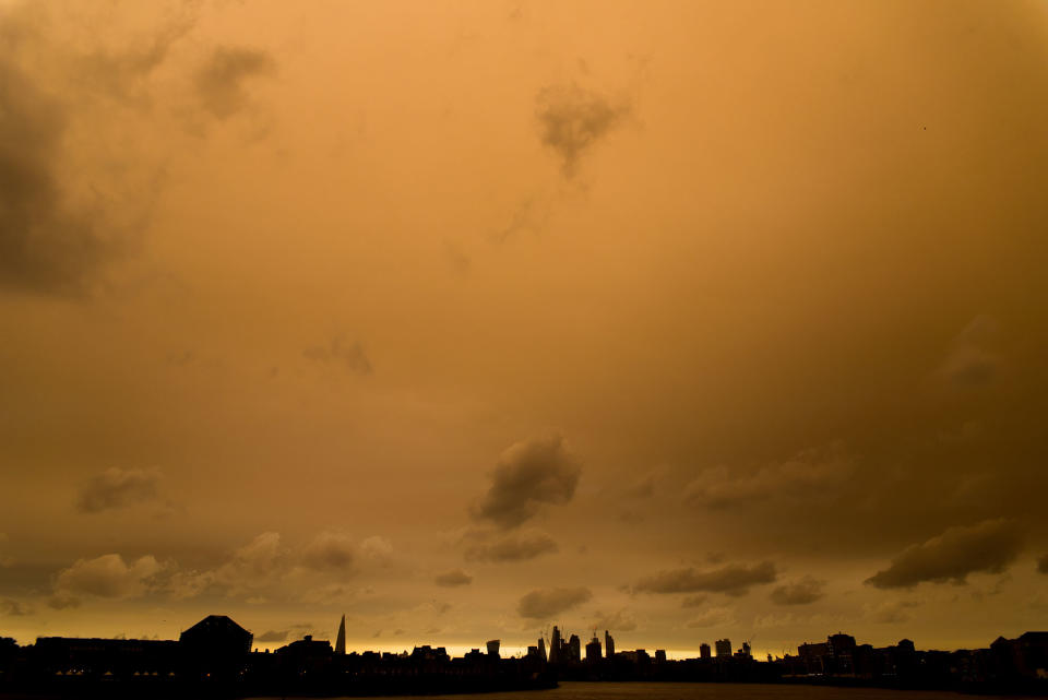 <p>Darkened sky over London is pictured at financial district of Canary Wharf, London on October 16, 2017. The darkening is caused by warm air and dust swept up by storm Ophelia. The sun shone red and the sky darkened to a foreboding orange and brown across parts of Britain (Photo: Alberto Pezzali/NurPhoto via Getty Images) </p>