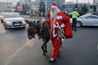 <p>Ein Mann in einem Weihnachtsmannkostüm läuft mit seinem Esel auch nach Weihnachten noch durch die Straßen der nordrumänischen Stadt Piatra Neamt. (Bild: AP Photo/Vadim Ghirda) </p>