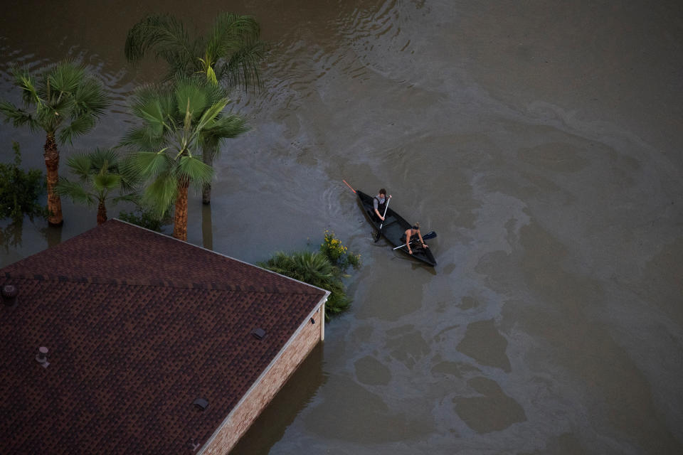 Residents use a canoe to navigate through flood waters.