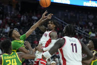 Arizona guard Caleb Love, center, passse around Oregon forward James Cooper during the first half of an NCAA college basketball game in the semifinal round of the Pac-12 tournament Friday, March 15, 2024, in Las Vegas. (AP Photo/John Locher)