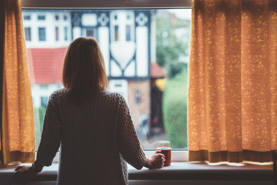 A former Sydney alcoholic has spoken of her addiction. Pictured is a stock image of woman at home staring through the window with a mug in hand.