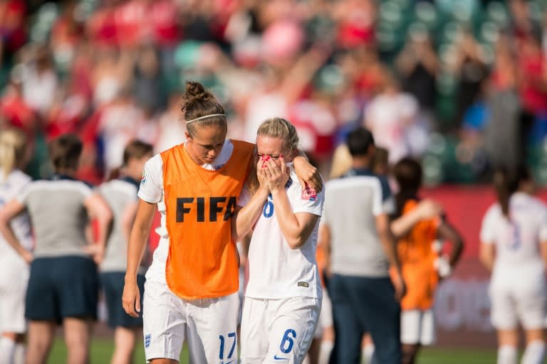 England's Jo Potter (L) consoles teammate Laura Bassett after she scored an own-goal in the last minutes of the game giving Japan the win in their semifinal match at the FIFA Women's World Cup in Edmonton, Canada on July 1, 2015