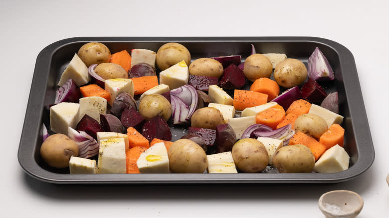 uncooked seasoned vegetables on baking sheet