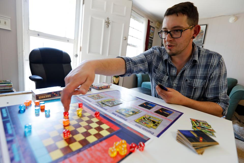 Recent UMass Dartmouth illustration graduate, Brian Fournier, plays a game of Arkadia, which he has designed and manufactured himself.