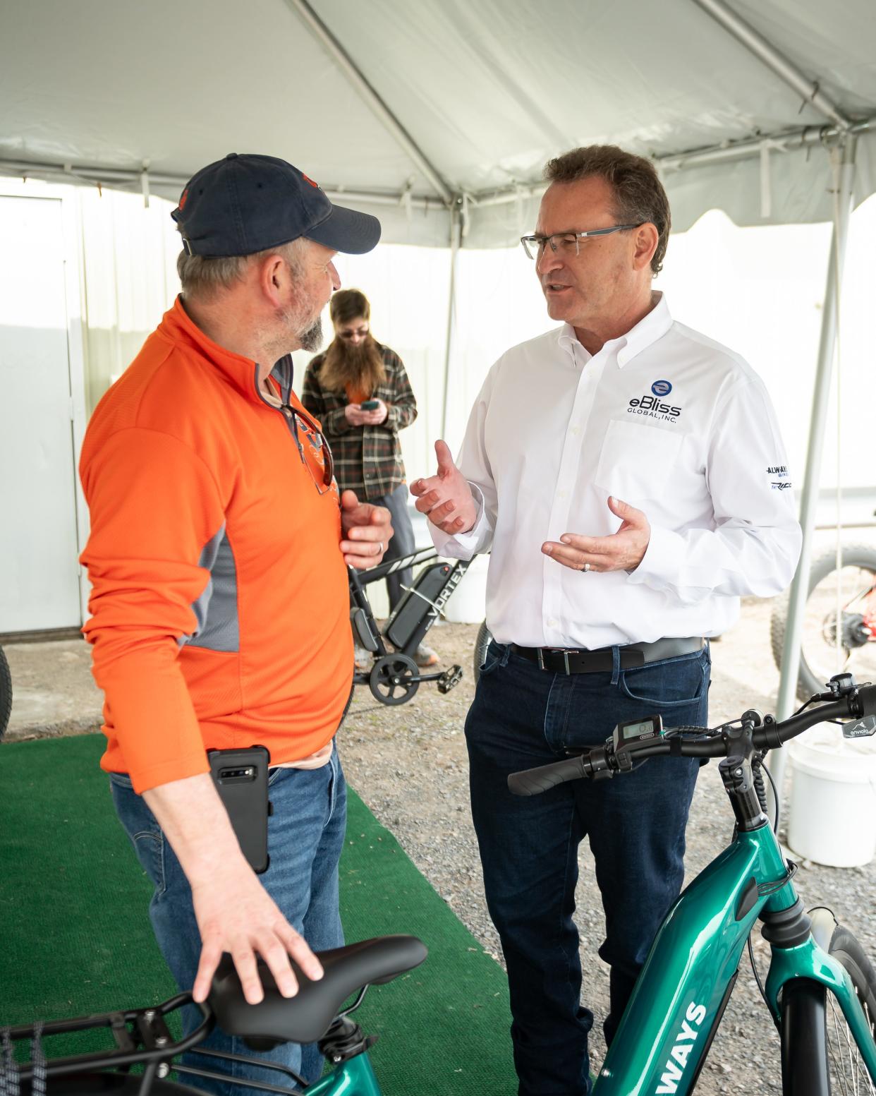 Adam Spooner (left) speaks to eBliss Global CEO Bill Klehm about bicycles at the new eBliss Experience Center in Clinton, NY on Saturday, April 27, 2024.