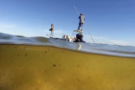 <p>Bob Chew, 64, of Edgewater, Fla., left, an avid fisherman and environmentalist, and Capt. Frank Brownell, 62, fish the murky waters of Mosquito Lagoon on the Indian River Lagoon, Fla., Feb. 17, 2016. The 153-mile-long Indian River Lagoon has suffered from harmful algae blooms caused by pollutants like fertilizers and human waste. (Photo: Red Huber/Orlando Sentinel via AP) </p>