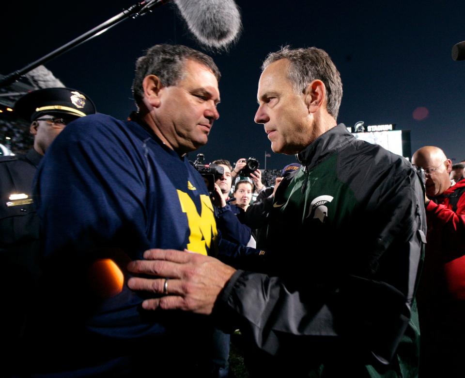 Michigan coach Brady Hoke, left, and MSU coach Mark Dantonio shake hands following the game Saturday, Oct. 25, 2014, in East Lansing.