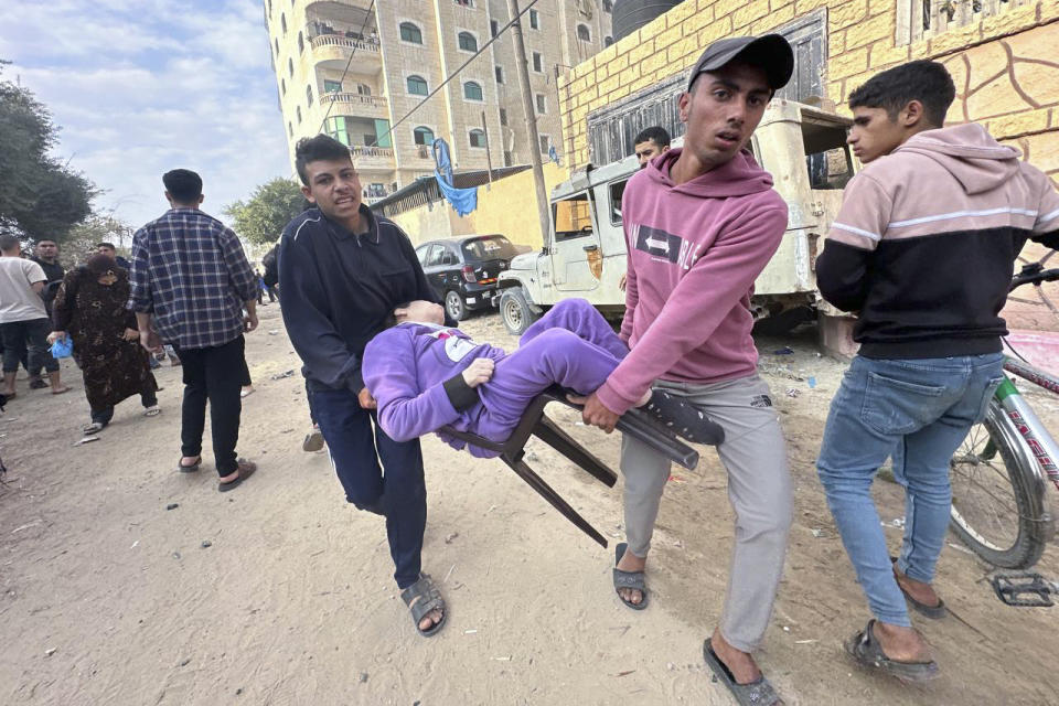 Palestinians evacuate a wounded child after an Israeli strike on Al Zawayda, central Gaza Strip, Thursday, Dec. 28, 2023. (AP Photo/Mohammed Asad)