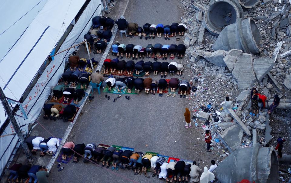 Palestinians hold Eid al-Fitr prayers by the ruins of al-Farouk mosque in Rafah