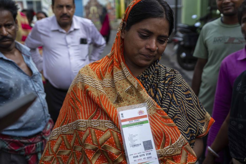 Bulti Khatun, whose husband is missing cries as she holds his Aadhaar card at a hospital in Balasore district, in the eastern state of Orissa, India, Sunday, June 4, 2023. The derailment in eastern India that killed 275 people and injured hundreds was caused by an error in the electronic signaling system that led a train to wrongly change tracks and crash into a freight train, officials said Sunday. (AP Photo/Rafiq Maqbool)