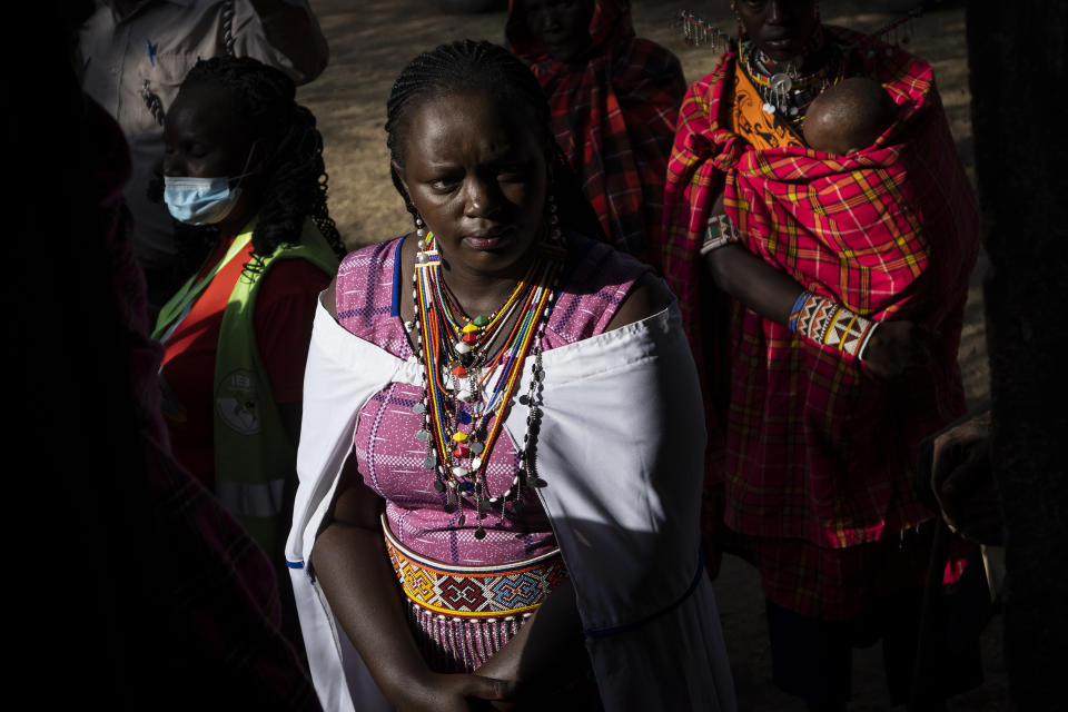 A Maasai woman waits in line to cast her vote in the general election at a polling station in Esonorua Primary School, in Kajiado County, Kenya Tuesday, Aug. 9, 2022. Polls opened Tuesday in Kenya's unusual presidential election, where a longtime opposition leader who is backed by the outgoing president faces the deputy president who styles himself as the outsider. (AP Photo/Ben Curtis)