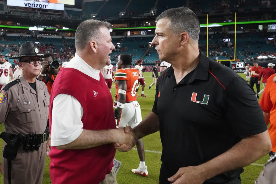 Miami (Ohio) head coach Chuck Martin, left, and Miami head coach Mario Cristobal congratulate each other after an NCAA college football game, Friday, Sept. 1, 2023, in Miami Gardens, Fla. (AP Photo/Wilfredo Lee)