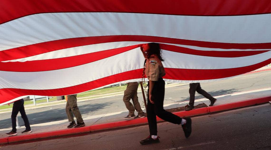Jonathon Villalobos, 12, of Boy Scout Troop 257 of Clovis, helps with the oversized U.S. flag during the Fresno Veterans Day Parade in downtown Fresno on Nov. 11, 2022.