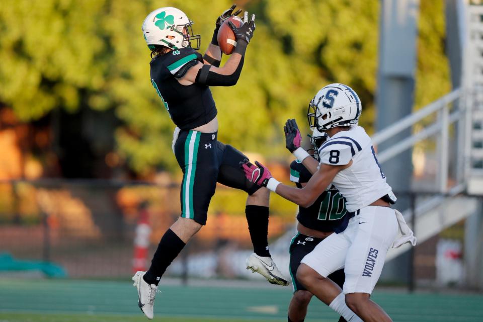 Jack Foster of Bishop McGuinness intercepts a pass beside Shawnee's Larron Thomas during a game last Thursday at Bishop McGuinness.