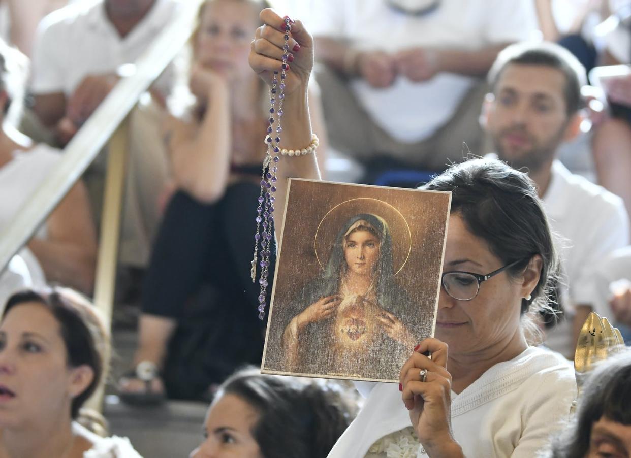 <span class="caption">A woman holds a rosary and a picture of the Virgin Mary during a 2019 hearing in Albany, N.Y., challenging the constitutionality of the state's repeal of the religious exemption to vaccination.</span> <span class="attribution"><a class="link " href="https://newsroom.ap.org/detail/VaccineExemptions/53d614f44967478da043ea27ef4e392d/photo?Query=religious%20vaccine%20exemption&mediaType=photo&sortBy=&dateRange=Anytime&totalCount=107&currentItemNo=8" rel="nofollow noopener" target="_blank" data-ylk="slk:AP Photo/Hans Pennink;elm:context_link;itc:0;sec:content-canvas">AP Photo/Hans Pennink</a></span>