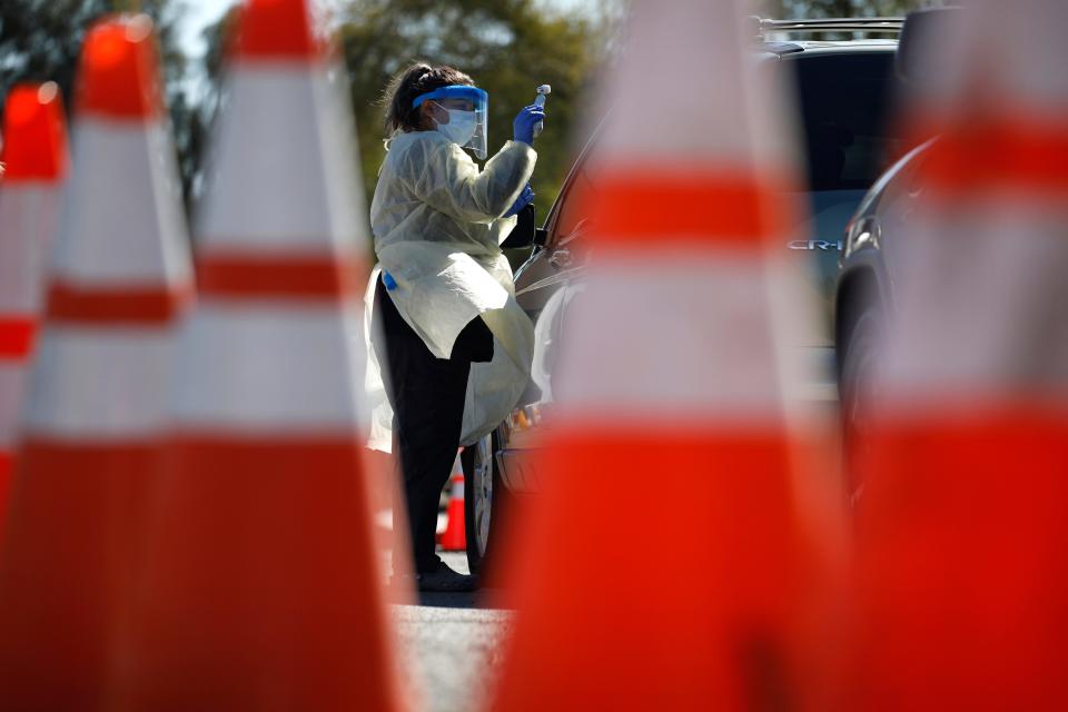 A health care worker with the University of Nevada, Las Vegas School of Medicine tests a patient for the coronavirus at a drive-through testing site March 24, 2020, in Las Vegas. UNLV Medicine, the clinical arm of the UNLV School of Medicine, started conducting COVID-19 testing by appointment for people who meet the Centers for Disease Control and Prevention guidelines.