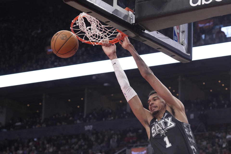 San Antonio Spurs center Victor Wembanyama (1) dunks against the Toronto Raptors during first-half NBA basketball game action in Toronto, Monday Feb. 12, 2024. (Chris Young/The Canadian Press via AP)