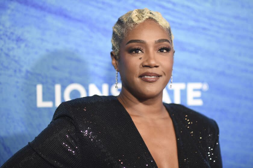 Tiffany Haddish wearing a black, sparkling gown at a premiere