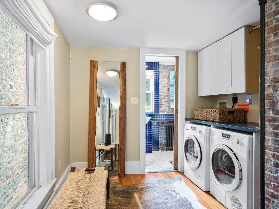 A washer and dryer on the right and windows on the left.