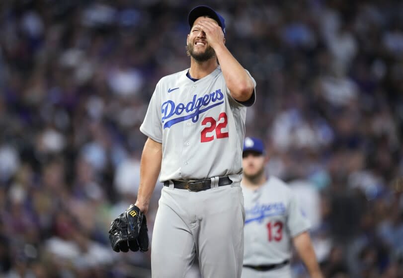 The Los Angeles Dodgers wait for pitcher Clayton Kershaw to be pulled from the mound.