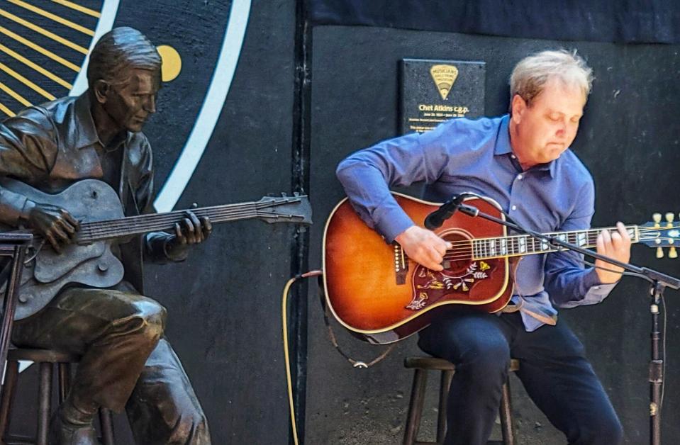 Steve Wariner plays while seated at the Chet Atkins statue now installed at the Musicians Hall of Fame in Nashville on June 9, 2023.