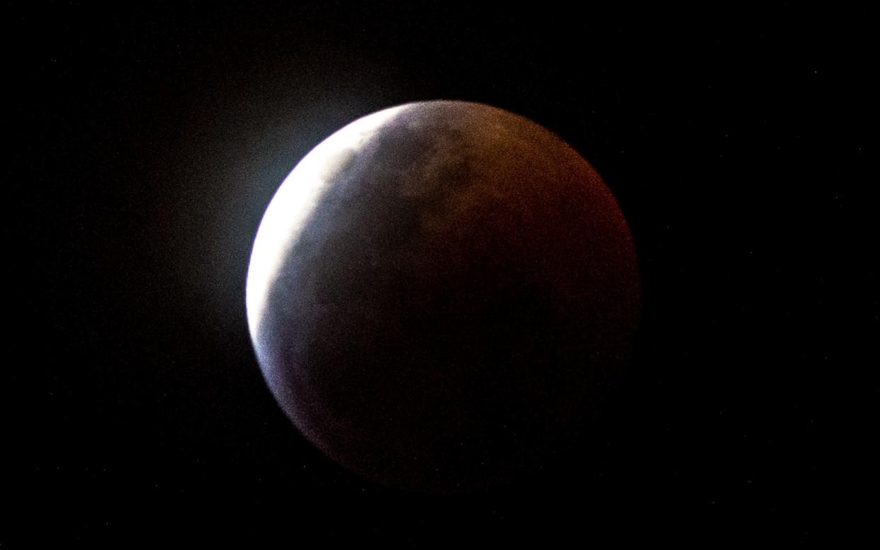 Earth's shadow almost totally obscures the view of the so-called Super Blood Wolf Moon during a total lunar eclipse - AFP