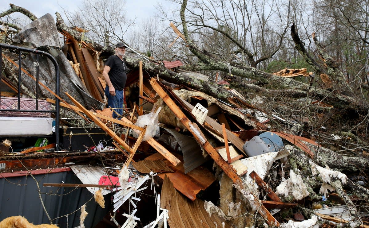 Larry Fondren sorts through the rubble of his mobile home (via REUTERS)