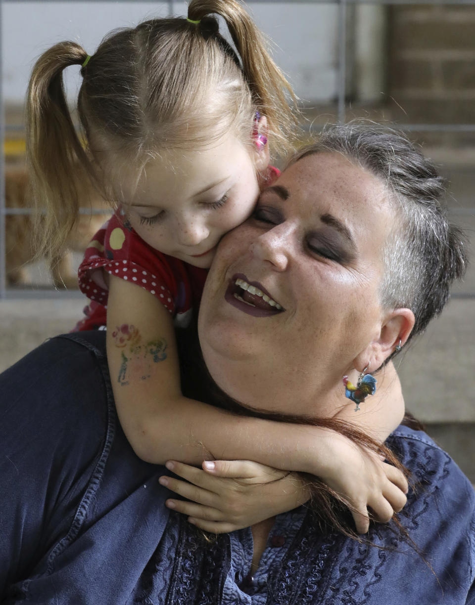 In this Thursday, June 6, 2019, photo, Victory hugs her mother Amie Schofield at their home, in Ogden, Utah. Victory has XXY chromosomes. Amie and her husband decided to raise Victory without pushing either gender. There would be no surgery. At 18 months, Victory began gravitating toward dresses and bows, and loudly insisting on wearing her hair long. (AP Photo/Rick Bowmer)