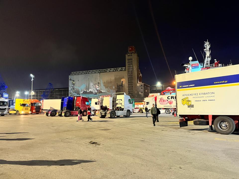 trucks and people at a port gate in athens greece