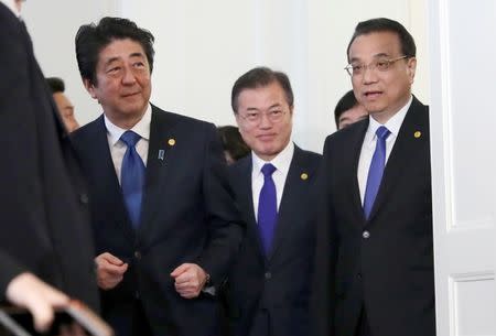 Chinese Premier Li Keqiang, Japanese Prime Minister Shinzo Abe and South Korean President Moon Jae-in walk together to their summit in Tokyo, Wednesday, May 9, 2018. Eugene Hoshiko/Pool via Reuters