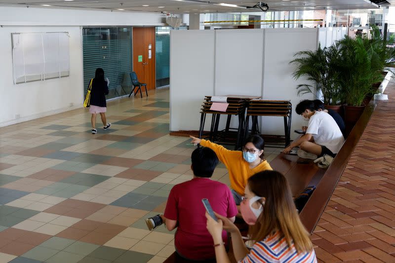 Students sit outside the former office of Hong Kong University Students' Union, which was ousted from campuses, in Hong Kong