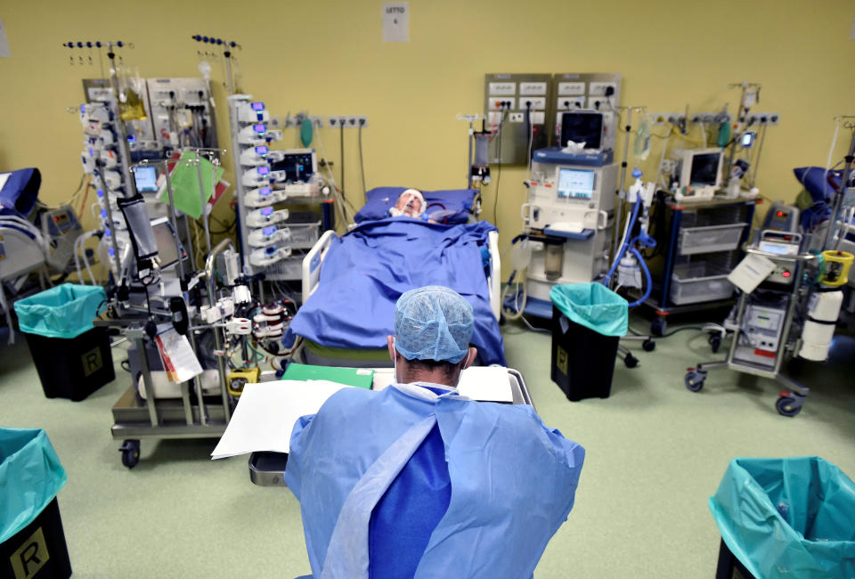 A member of the medical staff in a protective suit is seen in front of a patient suffering from coronavirus disease (COVID-19) in an intensive care unit at the San Raffaele hospital in Milan, Italy, March 27, 2020. REUTERS/Flavio Lo Scalzo     TPX IMAGES OF THE DAY