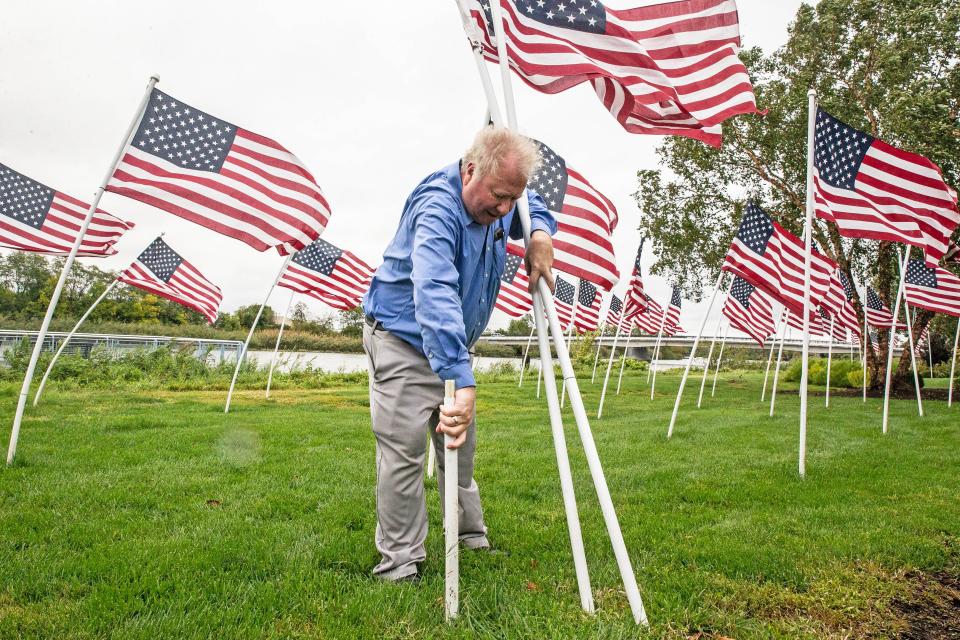 "It's a good day to be an American," said Tucker Robbins, from the Rotary Club of Wilmington, while adjusting and securing the hero flags uprooted by Tropical Storm Ophelia along the River North in Wilmington, Saturday, September 23, 2023. Wilmington saw intermittent winds, rain and drizzle.