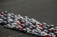 A worker walks beside newly produced cars at Keihin industrial zone in Kawasaki, Japan, September 14, 2016. Picture taken September 14, 2016. REUTERS/Toru Hanai