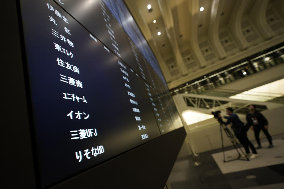 Members of media film the blank stock board at Tokyo Stock Exchange Thursday, Oct. 1, 2020, in Tokyo. The Tokyo Stock Exchange temporarily suspended all trading due to system problem. (AP Photo/Eugene Hoshiko)