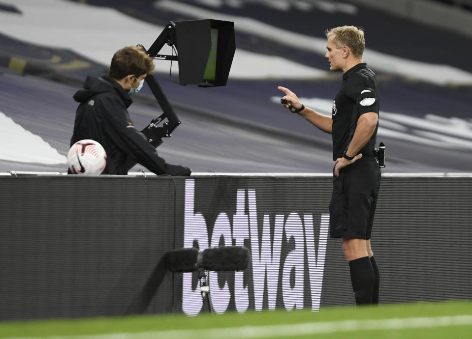 Referee Graham Scott consults with VAR before awarding a goal to Brighton's Tariq Lamptey during the English Premier League soccer match between Tottenham Hotspur and Brighton & Hove Albion at Tottenham Hotspur Stadium, London, Sunday, Nov. 1, 2020. (Mike Hewitt/Pool via AP)