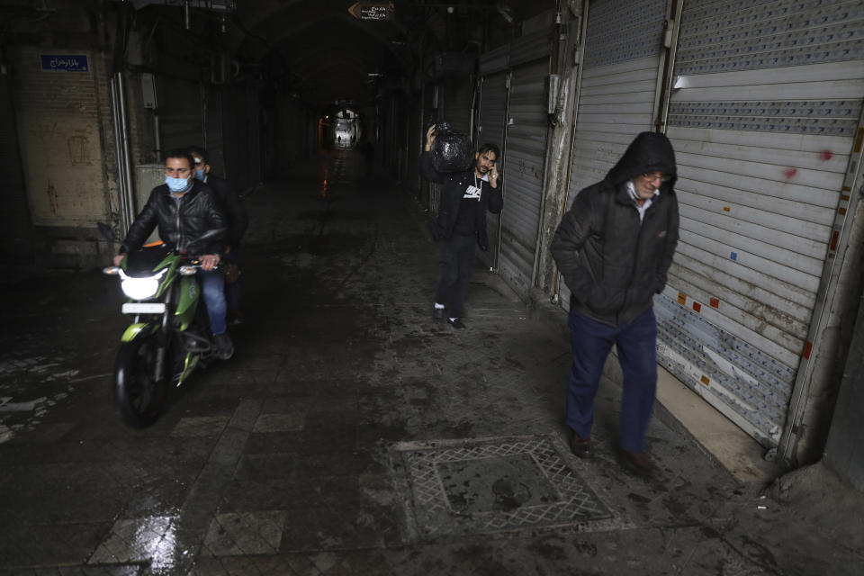 People leave the closed Tehran's Grand Bazaar, Iran's main business and trade hub, Satuday, Nov. 21, 2020. Iran on Saturday shuttered businesses and curtailed travel between its major cities, including the capital of Tehran, as it grapples with the worst outbreak of the coronavirus in the Mideast region. (AP Photo/Vahid Salemi)