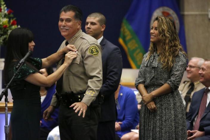LOS ANGELES, CA - DECEMBER 3, 2022 - - Celines Luna, from left, pins the badge on her husband Los Angeles County Sheriff Robert Luna as his children Asher Luna and Cesie Alvarez look on during the swearing-in ceremony at the Kenneth Hahn Hall of Administration Board Room in downtown Los Angeles on December 3, 2022. (Genaro Molina / Los Angeles Times)