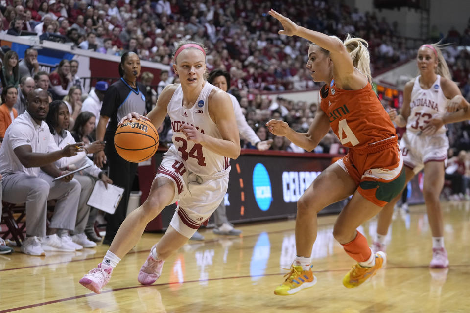 Indiana's Grace Berger (34) drives to the basket as Miami's Haley Cavinder defends during the first half of a second-round college basketball game in the women's NCAA Tournament Monday, March 20, 2023, in Bloomington, Ind. (AP Photo/Darron Cummings)