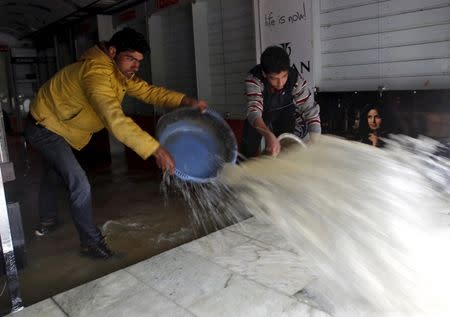 Men remove water from a water-logged shop after incessant rains in Srinagar March 29, 2015. REUTERS/Danish Ismail