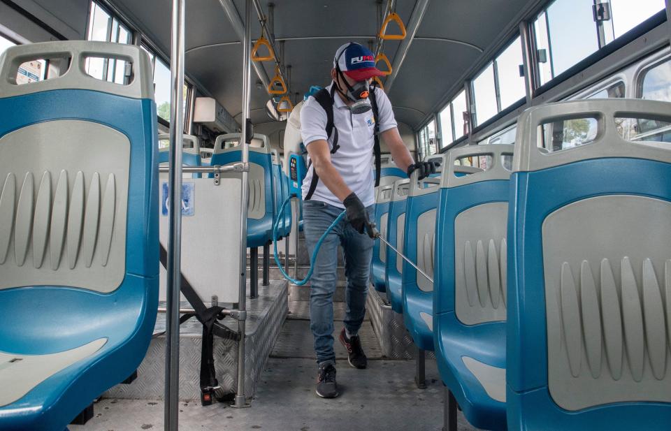 A worker disinfects a bus as a preventive measure against the spread of the new coronavirus, COVID-19, in San Jose, Costa Rica, on March 18, 2020. (Photo by Ezequiel Becerra / AFP) (Photo by EZEQUIEL BECERRA/AFP via Getty Images)