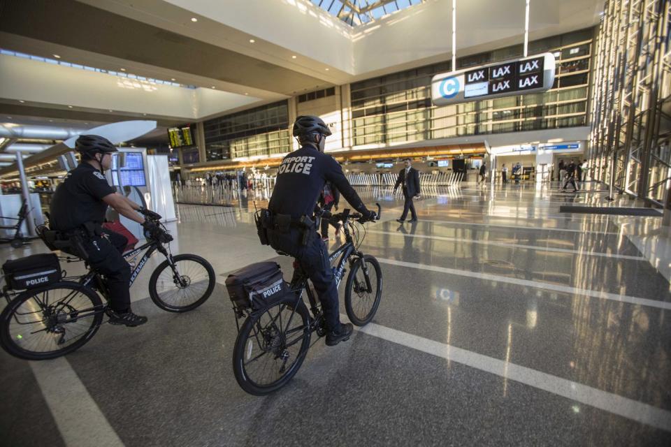 FILE - In this Nov. 2, 2013 file photo, airport police officers patrol the Tom Bradley International Terminal at the Los Angeles International Airport. Two armed police officers, not seen in this photo, assigned to guard a Los Angeles airport terminal where a gunman killed a screener in Nov. 2013, left for breaks without informing dispatchers as required minutes before the gunfire erupted. (AP Photo/Ringo H.W. Chiu, File)